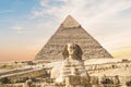 Great Sphinx against the background of the pyramids of the pharaohs Cheops, Khafren, and Mikerin in Giza Royalty Free Stock Photo