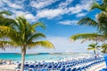 Great stirrup cay, Bahamas - January 08, 2016: sea beach, people, chairs, green palm trees on sunny day. Summer vacation, holidays Royalty Free Stock Photo