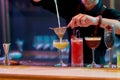 Great Taste. Close up of hands of male bartender pouring, mixing ingredients while making cocktails, alcoholic drinks at Royalty Free Stock Photo