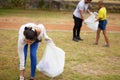 With great teaching, comes great leaders. a group of people picking up trash in a park. Royalty Free Stock Photo