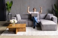 Great thing. Euphoric young man sit on couch by laptop screen shout super raise fists in winner gesture get good news job offer Royalty Free Stock Photo