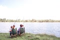 Great view of big river flowing. There is a family sitting by its shore and enjoying the moment. They are holding kids Royalty Free Stock Photo