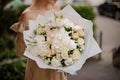 Great view of luxury bouquet of different white flowers in hands of woman
