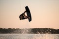 great view of muscular man making trick in jump time with wakeboard against the backdrop of the sky Royalty Free Stock Photo