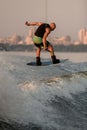 great view of a muscular man with a wakeboard while jumping over the wave