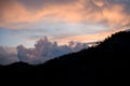 Great view on sky and clouds at sunrise. Dark silhouettes of mountains at dawn.