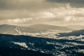 Great view of the village in the snow between forest and the mountains on a cloudy day