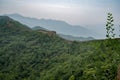 Great view from Great Wall of China with a green trees and rocky mountains in the background. Misty foggy air above the hill Royalty Free Stock Photo