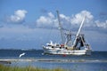 Great white heron flies by a shrimping boat as it heads out Royalty Free Stock Photo