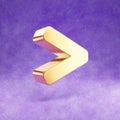 Greater than icon. Gold glossy Greater than symbol isolated on violet velvet background.