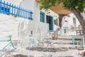 Greece, Amorgos island, Beautiful traditional greek street with flowers and cafe tables Royalty Free Stock Photo