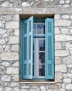 Greece, blue shutters window on traditional island house stone wall Royalty Free Stock Photo