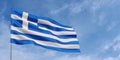 Greece flag on flagpole on blue sky background. Greek flag waving in the wind on a background of sky with clouds. Place for text. Royalty Free Stock Photo