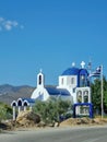 Greece. Greek flag waving on white orthodox church with blue dome against blue clear sky background, vertical photo Royalty Free Stock Photo