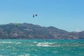 13.07.2014. Greece. Heraklion. Two persons of the surfer ride a kite. Two domes highly in the clear blue sky. Windy weather Royalty Free Stock Photo