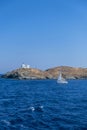 Greece, Kea Tzia island. Seascape with lighthouse and a sailboat, clear blue sky