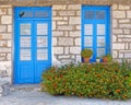 Greece, marigold flowers in front of blue door and window, house facade Royalty Free Stock Photo