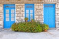 Greece, marigold flowers in front of blue doors and window, house facade Royalty Free Stock Photo