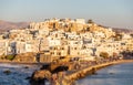 Greece, Naxos harbor jetty, Cyclades islands. View from ship of houses colored from sundown