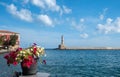 Greece, Old Town of Chania Crete. View of beacon from outdoors cafe. Potted petunia on table Royalty Free Stock Photo