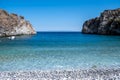 Greece. Pebble beach, moored boat in calm sea, Mani Laconia, Peloponnese crystal clear water Royalty Free Stock Photo