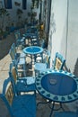 Greece, tables outside a cafe in the Chora on the island of Amorgos. Royalty Free Stock Photo