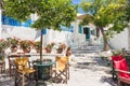 Greece travel landscape, traditional greek tavern on Amorgos island, beautiful street with flowers and cafe tables Royalty Free Stock Photo