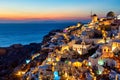 Greece vacation background. Famous iconic Oia village with traditional white houses and windmills during colorful sunset. Royalty Free Stock Photo