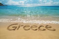 Greece written in the sand on a beach. Greek tourism and vacation background Royalty Free Stock Photo