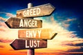 Greed, anger, envy, lust - wooden signpost, roadsign with four arrows