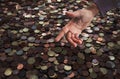 Greediness for money concept, coins background with stretching hand, finance, expenses, savings Royalty Free Stock Photo