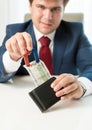 Greedy businessman pulling money out wallet with use of magnet Royalty Free Stock Photo