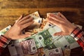 Greedy hands withdrawing pile of euro banknotes cash