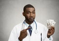 Greedy health care professional, doctor holding cash, money