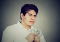 Greedy suspicious man holding money dollar bills in hand