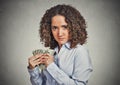 Greedy woman corporate business employee holding dollar banknotes tightly