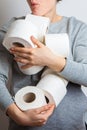 Greedy woman holds an armful of toilet rolls. Panic. stocks during the quarantine period of the coronavirus pandemic