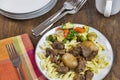 Greek beef stifado with egg noodles and roasted vegetables