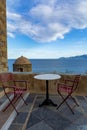 Greek cafe or tavern with small table on outside terrace with nice view Royalty Free Stock Photo