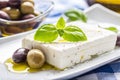 Greek cheese feta with olive oil olives and basil leaves Royalty Free Stock Photo