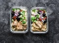 Greek chicken grain lunch box. Lemon herbs chicken, couscous, vegetables, olives, feta cheese lunch box on dark background, top