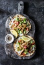 Greek chicken gyros flatbread on a rustic cutting board on a dark background, top view