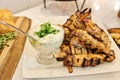 Greek chicken souvlaki skewers or kebabs piled high on a white plate with a bowl of tzatziki sauce Royalty Free Stock Photo