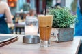 A greek cold coffee, freddo cappuccino placed on a wooden table outdoors. Royalty Free Stock Photo