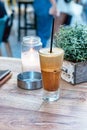 A greek cold coffee, freddo cappuccino placed on a wooden table outdoors. Royalty Free Stock Photo