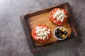 Greek dakos appetizer with barley rusk, tomatoes, feta cheese, oregano and olive oil closeup on the wooden board. Horizontal top