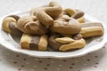 Greek dichromatic sweet cookies in white bowl on dotted talbecloth