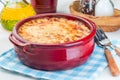 Greek dish moussaka made in traditional ceramic pot, horizontal, closeup