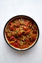 Greek eggplant meze in ceramic bowl with spoon. Baked eggplants with tomatoes and peppers with garlic.