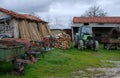 Greek farmhouse with farming equipment, tractor and wood pile.